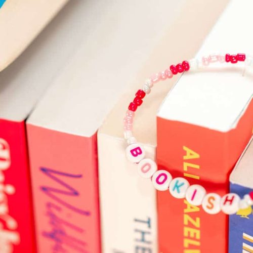 Close up van roze bookish armbandje op een rij boeken