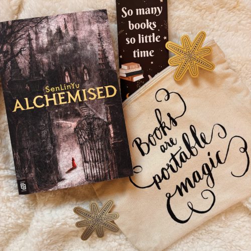 Het boek Alchemised met een bladwijzer waarop staat 'So many books, so little time'