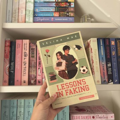 Het boek 'Lessons in faking' van Selina Mae voor een boekenkast